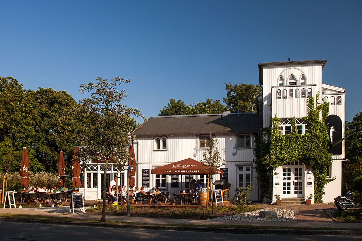 Exterior view of the Hotel Künstlerquartier Seezeichen in Ahrenshoop with half-timbered architecture and inviting terrace.