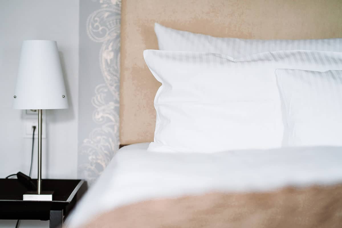 Cozy bed with soft pillows in the bedroom of the Junior Suite of the Hotel Künstlerquartier Seezeichen.