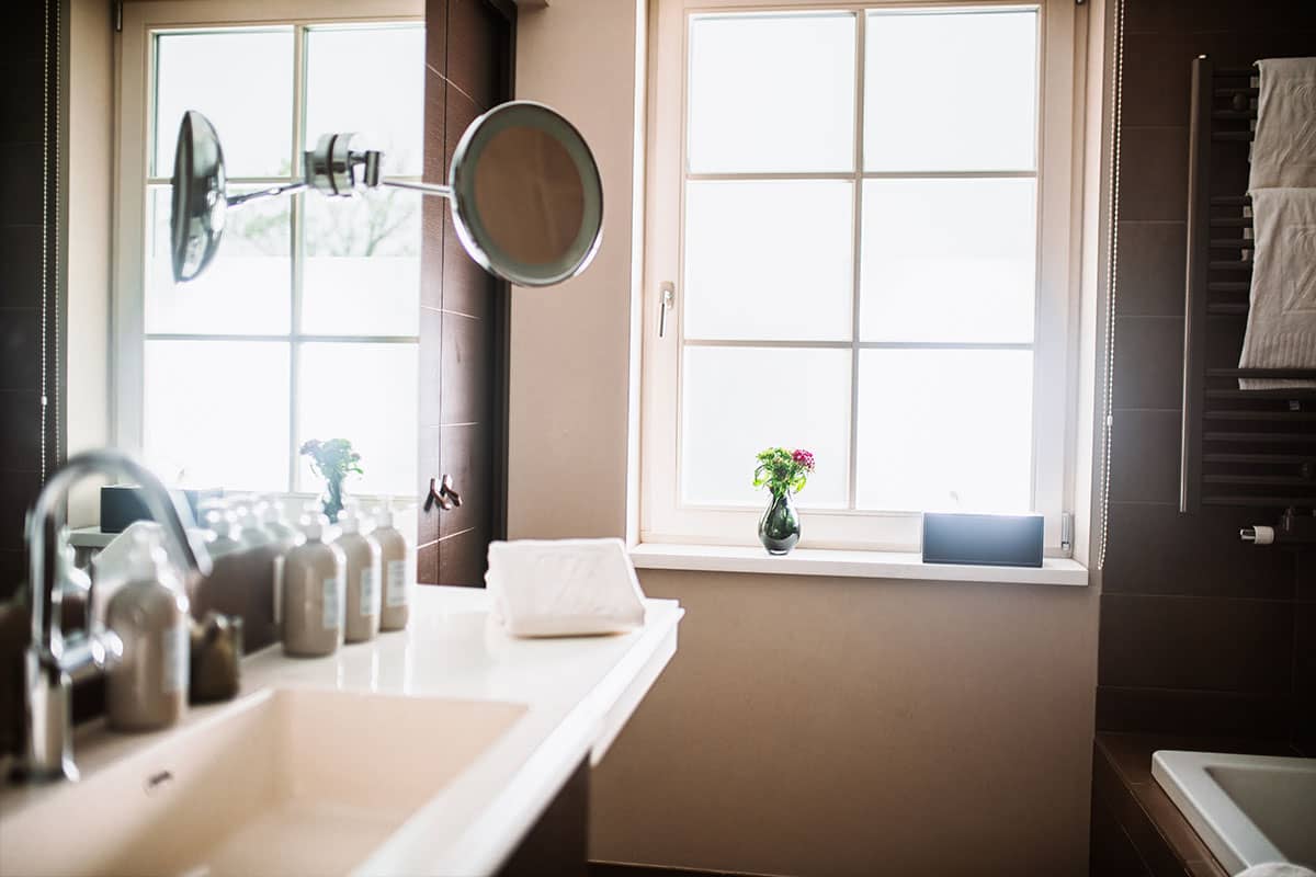 Bathroom in the Junior Suite of the Hotel Künstlerquartier Seezeichen with large mirror, washbasin and toiletries.