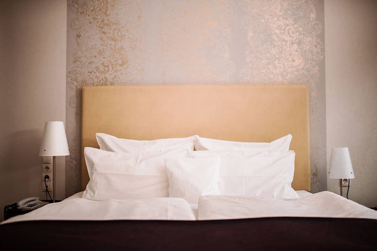 Comfortable double bed with soft bed linen in the Comfort double room at the Hotel Künstlerquartier Seezeichen.