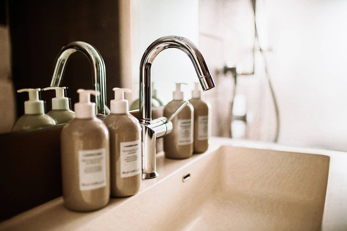 Close-up of a tap with elegant care products in the Comfort double room of the Künstlerquartier Seezeichen.