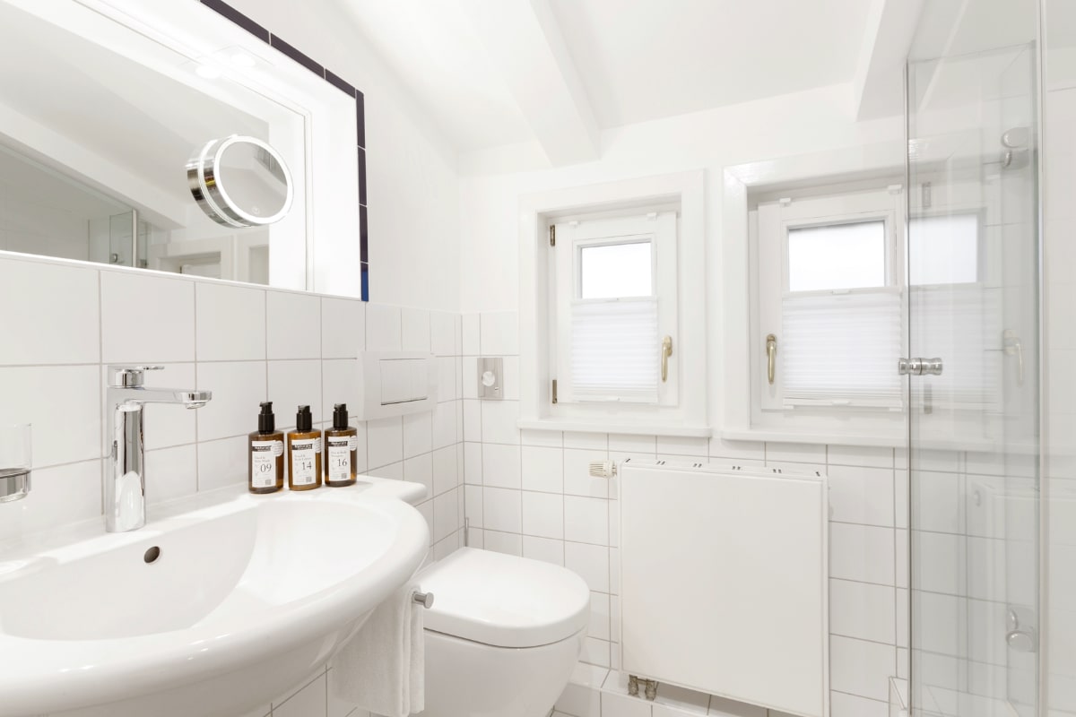 Bathroom with shower, washbasin and high-quality furnishings in the single room of the Elisabeth von Eicken Hotel.