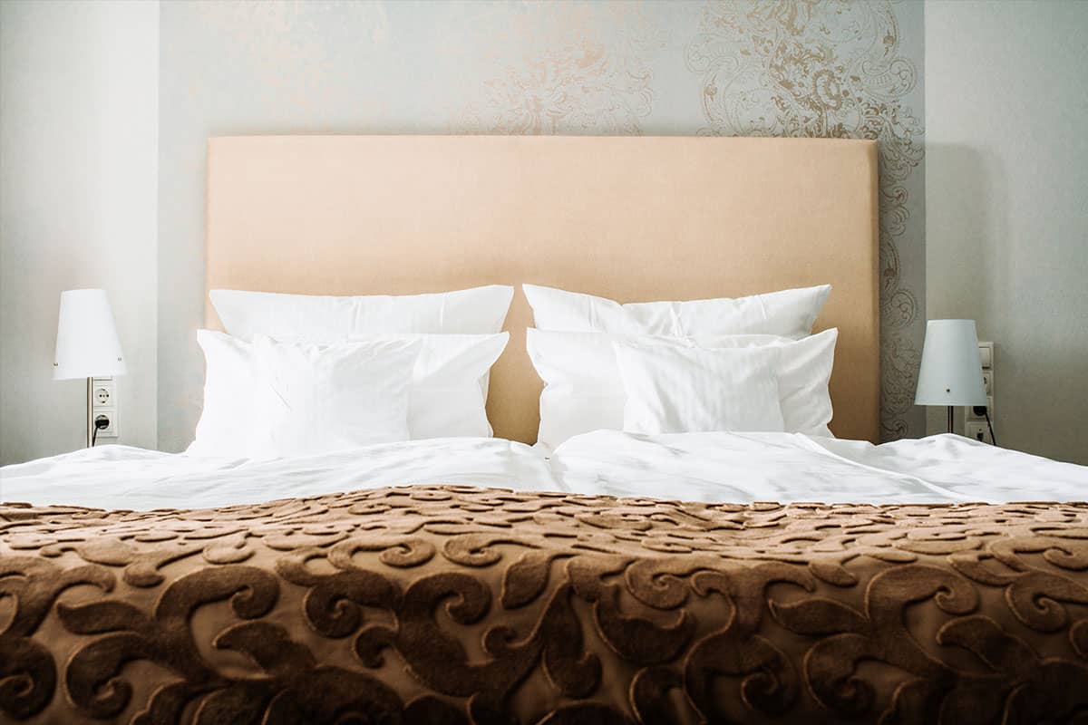 Comfortable double bed in the first-class double room of the Hotel Künstlerquartier Seezeichen with elegant furnishings.