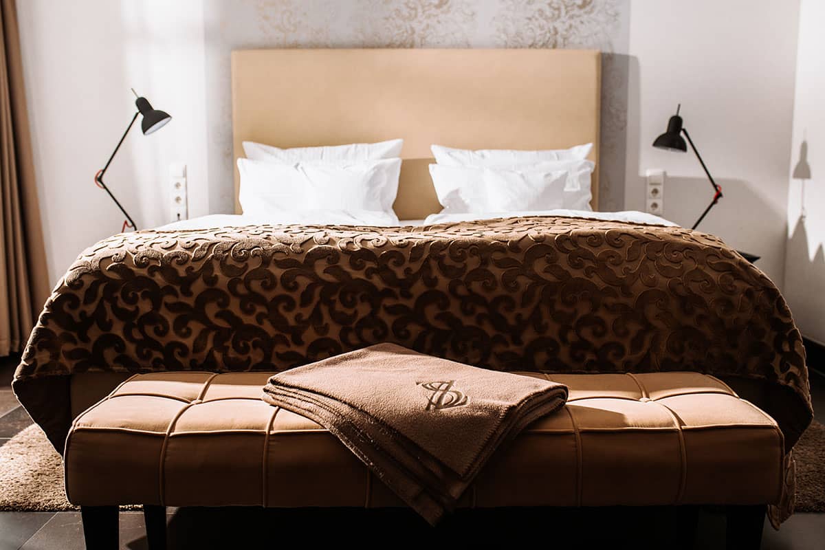 Double bed in the first-class double room with soft comforter and stylish headboard at the Hotel Künstlerquartier Seezeichen.