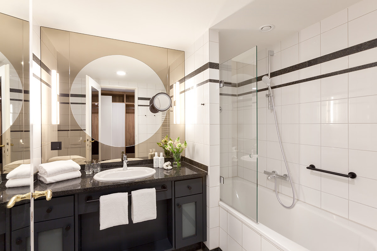Helles Bad mit großem Spiegel, einladender Badewanne und hochwertiger Ausstattung in der Familiensuite im Vju Hotel.