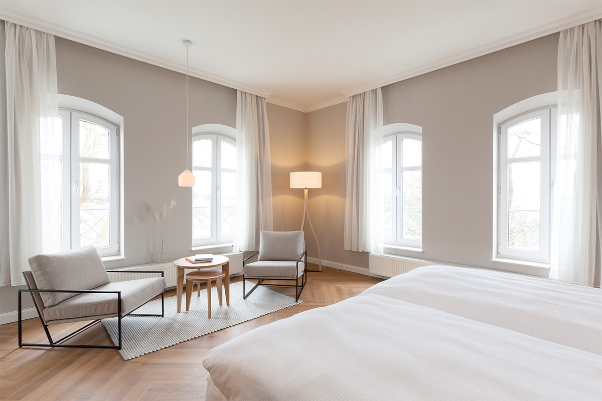Heller Sitzbereich in der Familiensuite mit zwei bequemen Sesseln in der 2-Raum Familiensuite mit Balkon im Vju Hotel.