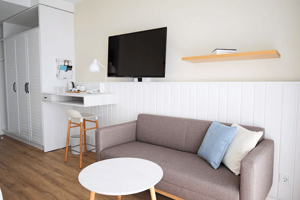 Gemütliche Sitzecke mit stilvollem Sofa im Muschelsucher-Zimmer des Wyn. Strandhotels für entspannte Momente auf Sylt.