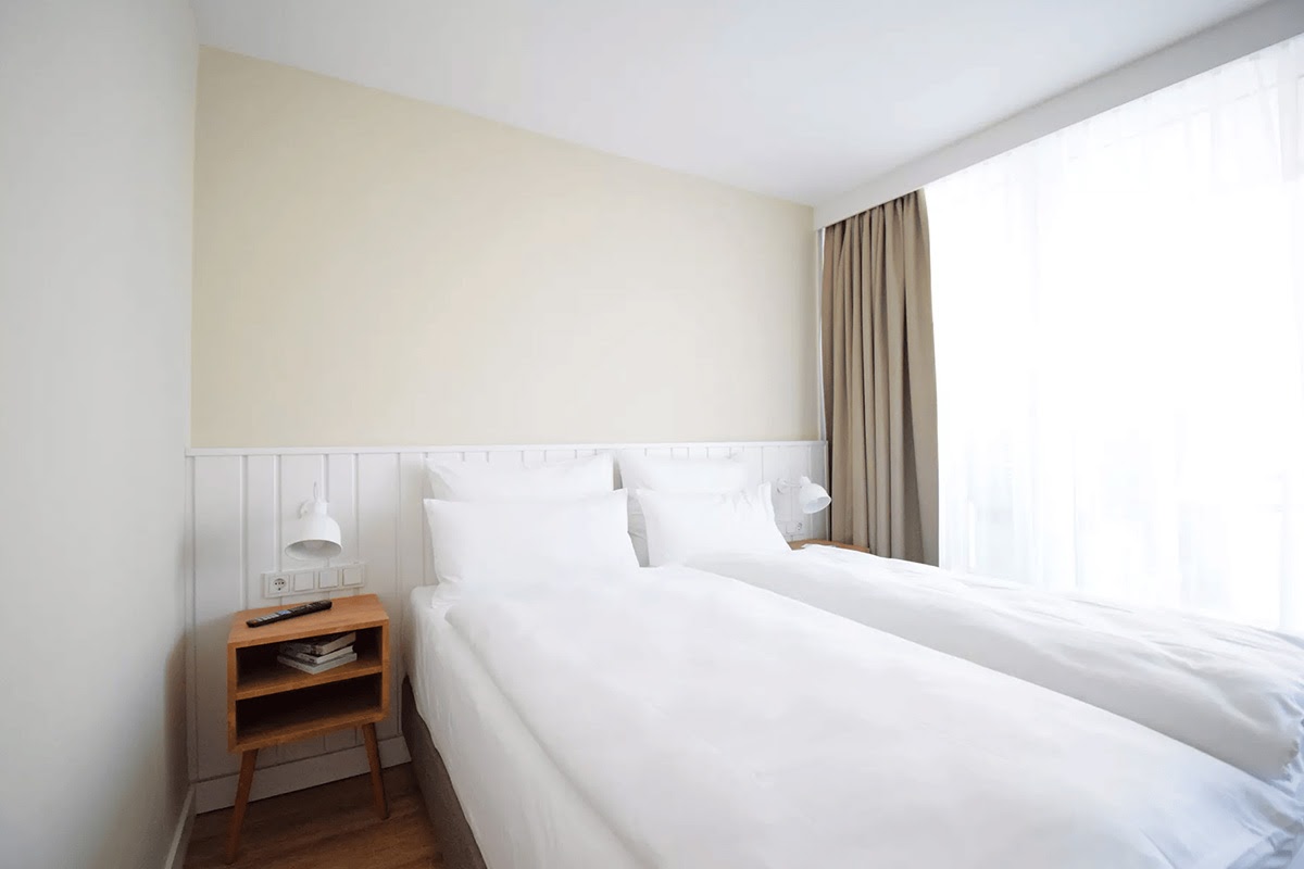 Gemütliches Schlafzimmer mit Doppelbett und Tageslicht im Westerland-Zimmer des Wyn. Strandhotels auf Sylt.