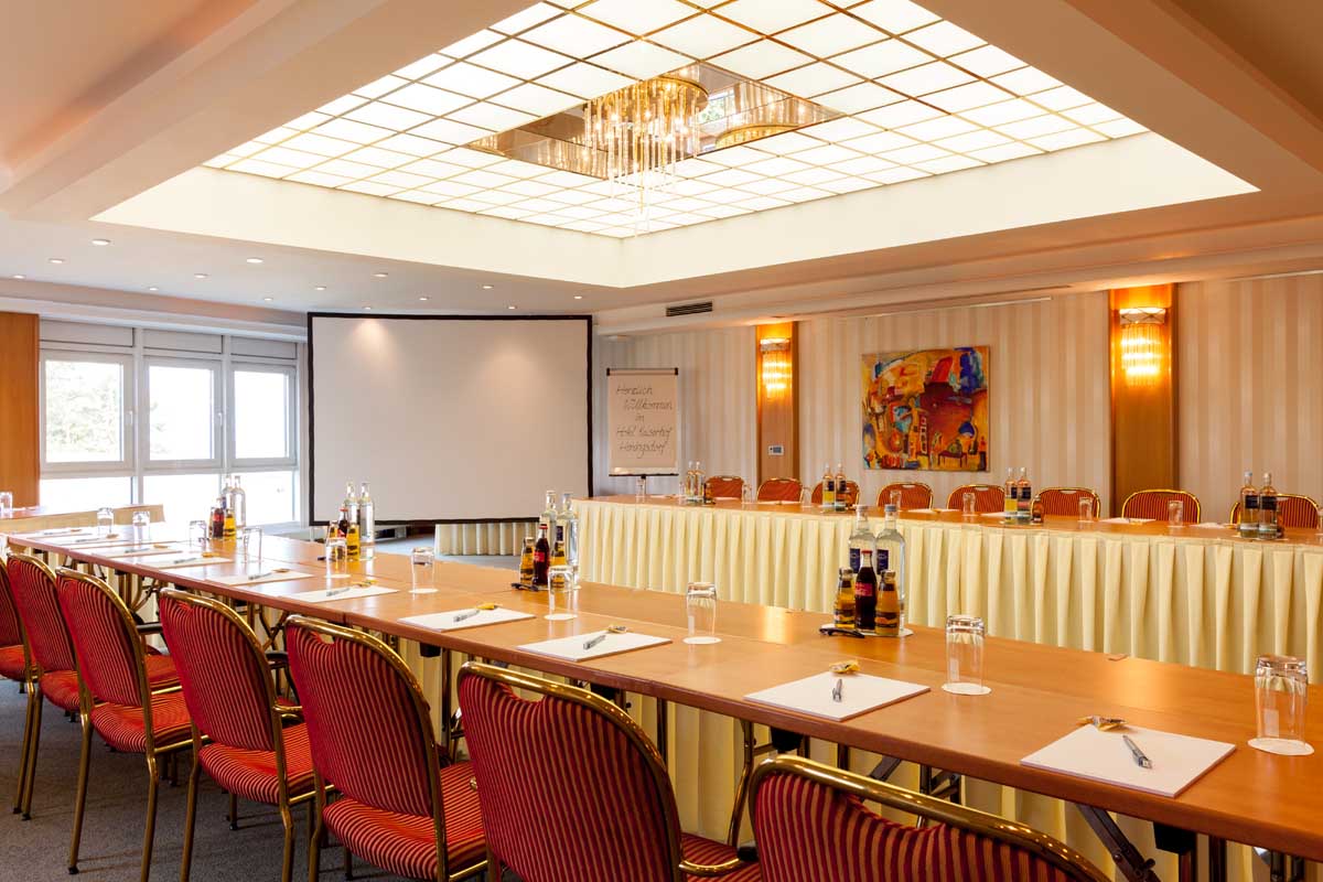 Geräumiger Konferenzraum im Hotel Kaiserhof Heringsdorf, ausgestattet mit modernen Tischen, Stühlen und Präsentationstechnik.