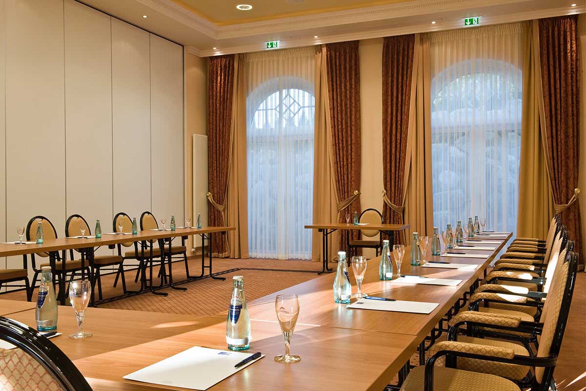 Heller Tagungsraum im Vju Hotel auf Rügen mit langen Konferenztischen, Wasserflaschen und Schreibmaterial für Meetings.